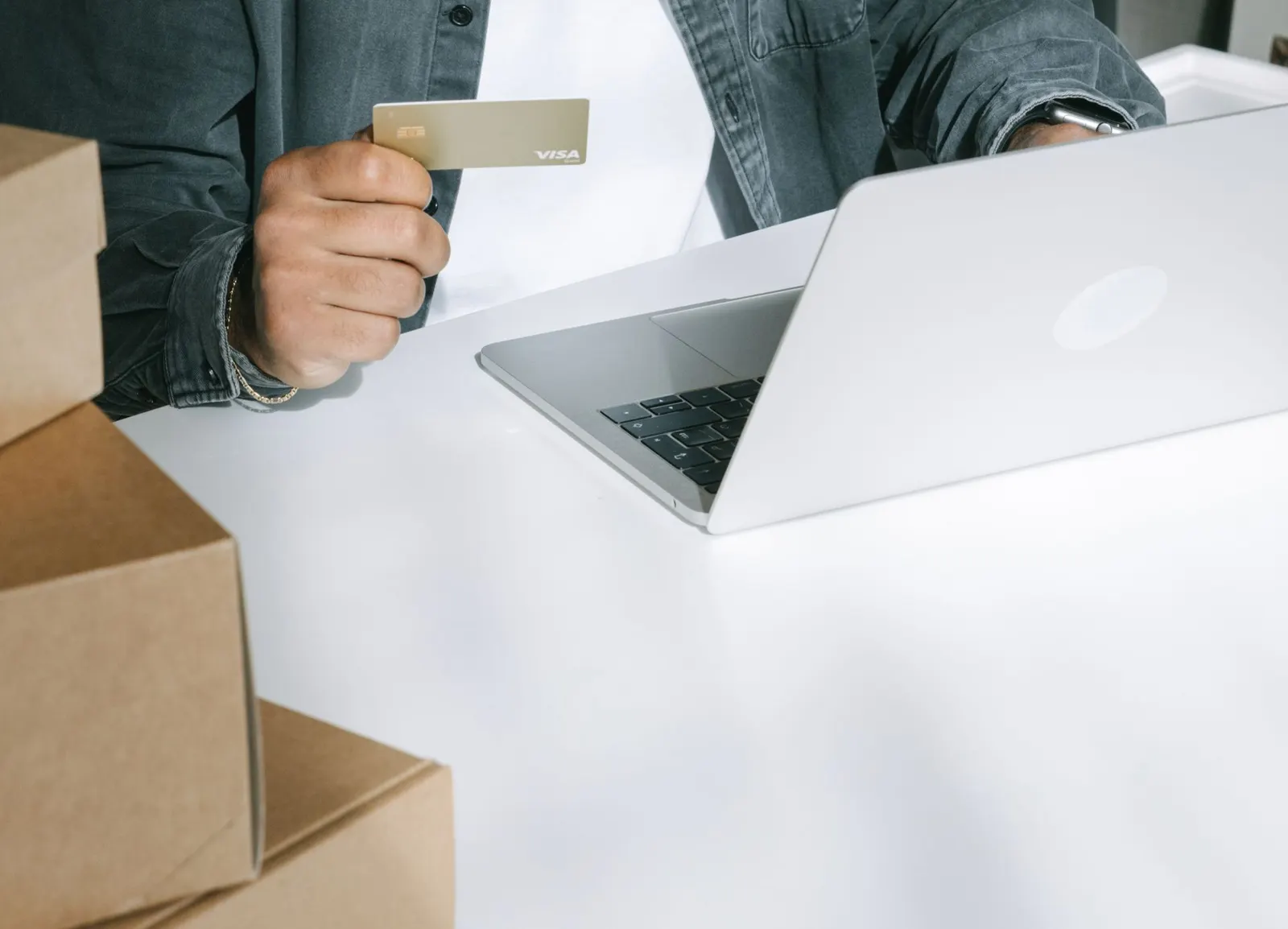Compra online con tarjeta rodeada de cajas de envío