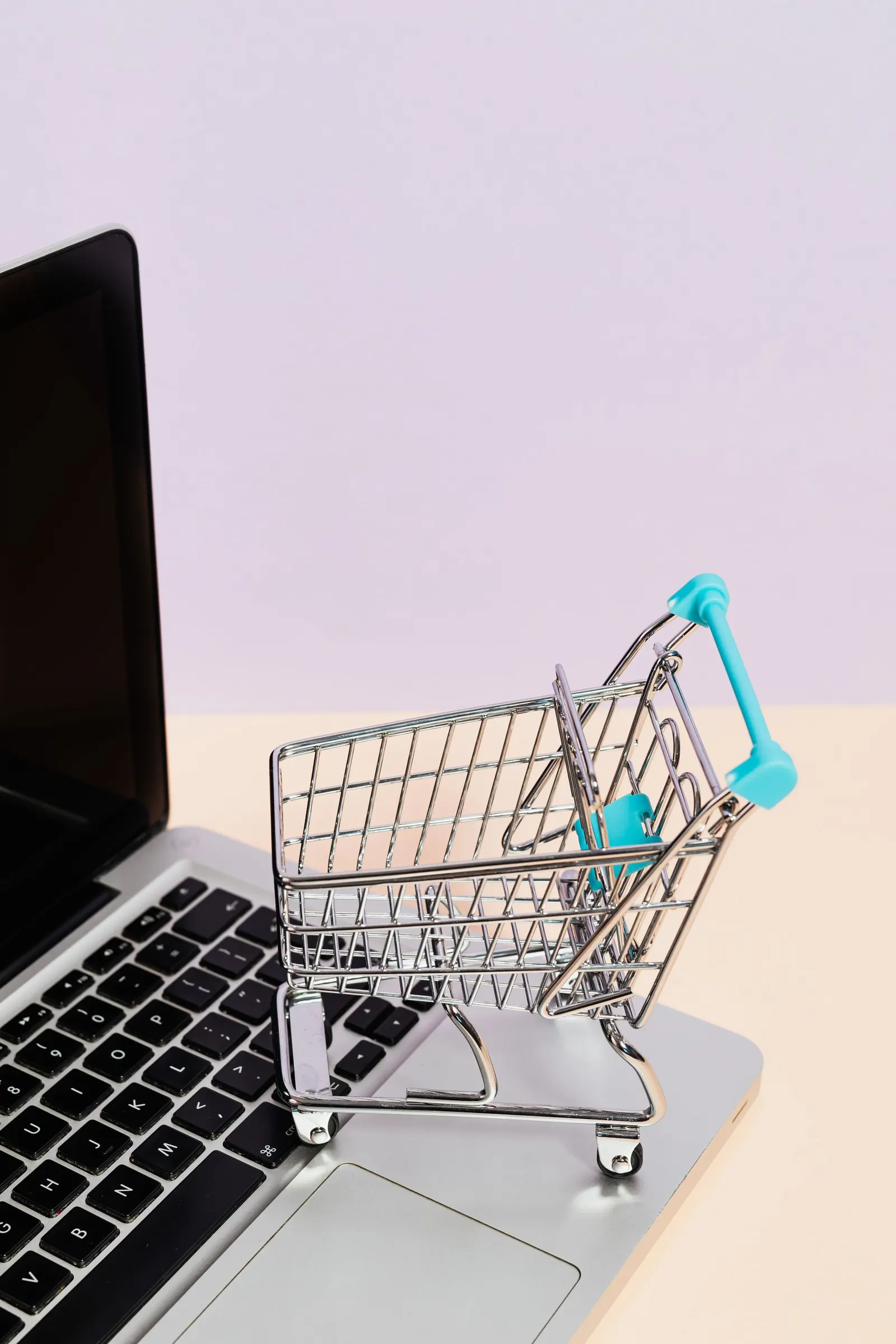 Carrito de la compra en miniatura sobre el teclado de un portátil